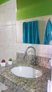 um balcão de casa de banho com um lavatório e uma toalha azul em Pousada Barra Sol em Barra Grande