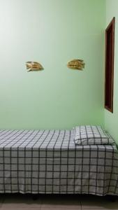 uma cama num quarto com duas placas de animais na parede em Pousada Barra Sol em Barra Grande
