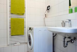 a bathroom with a washing machine and a sink at Appartement über dem Kino Toni in Berlin +4 photos