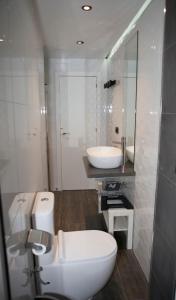 y baño con aseo, lavabo y espejo. en Apartamento de Sonia II - Plaza de Garaje, en Lugo