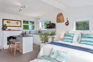 Biała sypialnia z łóżkiem i kuchnią w obiekcie Seaview Studio w mieście Ohope Beach