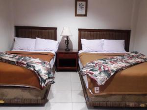 two beds sitting next to each other in a room at S & C Hotel Suites & Apartment in Koror