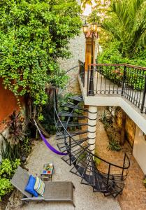 a spiral staircase in a garden with a bench at Casa Del Maya Bed & Breakfast in Mérida