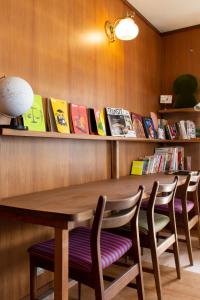 una mesa y sillas en una habitación con libros en Yuzan Guesthouse, en Nara