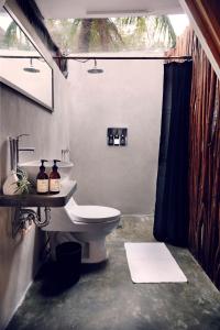 uma casa de banho com um WC e um lavatório em Frequency em Holbox