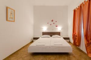 een slaapkamer met een wit bed en oranje gordijnen bij One-Bedroom Apartment Crikvenica near Sea 3 in Crikvenica