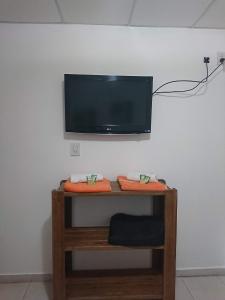 a tv on a wall with a shelf with towels at DEPARTAMENTO TEMPORARIO DONOVAN in Resistencia