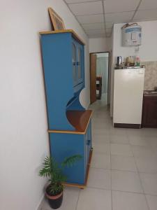 DEPARTAMENTO TEMPORARIO DONOVAN في ريزيستينسيا: مطبخ مع خزانة زرقاء وثلاجة