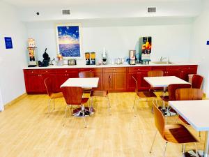 a dining room with tables and chairs and a kitchen at Americas Best Value Inn & Suites Porter North Houston in Porter