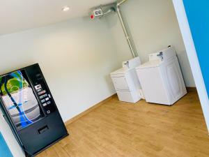 a room with a refrigerator and two washer and dryers at Americas Best Value Inn & Suites Porter North Houston in Porter
