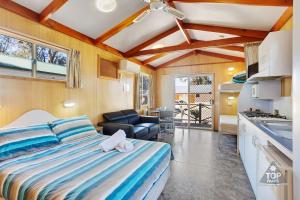 a bedroom with a bed and a living room at Boomerang Way Tourist Park in Tocumwal