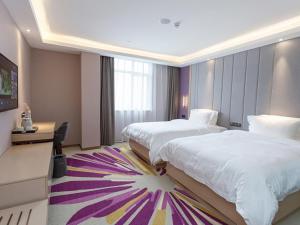 a hotel room with two beds and a tv at Lavande Hotel (Yongxin Bubugao Times Square) in Yongxin