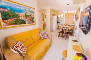 sala de estar con sofá amarillo y cocina en Eco Summer Flat Tambaú, en João Pessoa