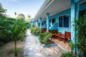 a blue house with benches and plants in front of it at Blue Corals Beach Resort in Malapascua Island