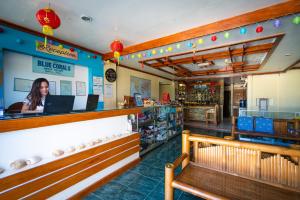 Blue Corals Beach Resort في جزيرة مالاباسكوا: وجود امرأة جالسة في كونتر مطعم