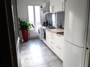 a kitchen with white appliances and a tile floor at Apartment with Car Park - Bastille Neighborhood in Paris