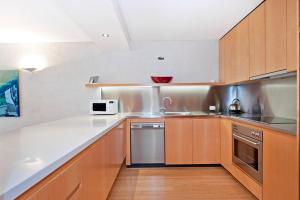 a kitchen with wooden cabinets and a white counter top at 1/18 Allambi Rise in Noosa Heads