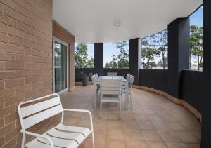 a patio with a table and chairs and windows at Sydney Airport Suites in Sydney