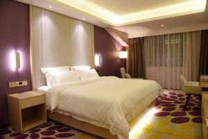 una camera d'albergo con un grande letto con cuscini bianchi di Lavande Hotel (Yichun Wanzai Ancient Town) a Wanzai