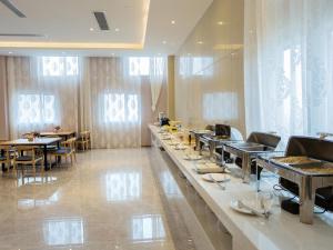 a restaurant with a long buffet line with tables at Lavande Hotel (Yongxin Bubugao Times Square) in Yongxin