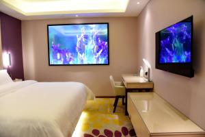ein Hotelzimmer mit einem Bett und einem Flachbild-TV in der Unterkunft Lavande Hotel (Yichun Wanzai Ancient Town) in Wanzai