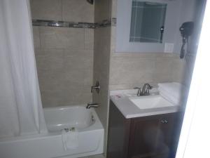 ein Badezimmer mit einem Waschbecken, einer Badewanne und einem WC in der Unterkunft Sierra Inn in Prescott