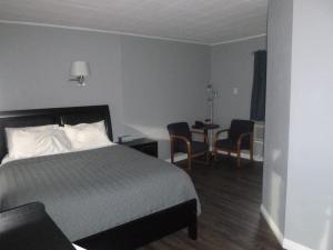 ein Hotelzimmer mit einem Bett, einem Tisch und Stühlen in der Unterkunft Sierra Inn in Prescott