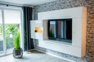 uma sala de estar com televisão numa parede de tijolos em Home em Dahme