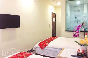 Pokój z dwoma łóżkami i telewizorem na ścianie w obiekcie Sun Moon Lake Crown Yu Hotel w mieście Yuchi