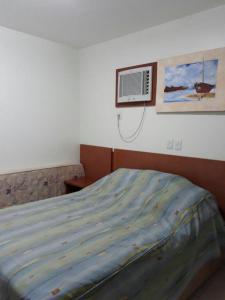 a bedroom with a bed and a air conditioner on the wall at APARTAMENTO JARDINS DAS THERMAS CALDAS NOVA in Caldas Novas