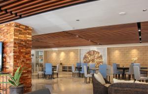 a restaurant with chairs and tables in a lobby at Acacia Hotel Bacolod in Bacolod