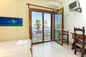 a bedroom with a bed and a sliding glass door at Melas Apartments in Agios Nikolaos