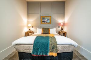 Poshtel في أومارو: غرفة نوم مع سرير مع بطانية ملونة عليه