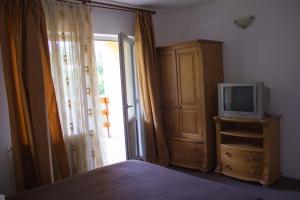 um quarto com uma cama e uma televisão numa cómoda em Pension Belmonte em Sâmbăta de Sus