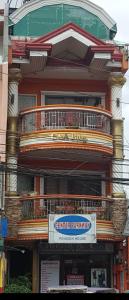 a large building with a balcony on top of it at Center Parkway Pension House in Kalibo