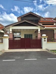 una casa con una puerta roja en un estacionamiento en The oasis en Kuching