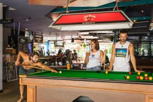un gruppo di persone che giocano a biliardo in un negozio di Summer House Backpackers Cairns a Cairns