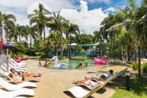 een groep mensen in het zwembad van een resort bij Summer House Cairns in Cairns