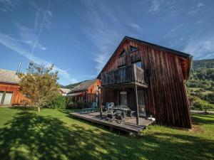 a wooden house with a deck in the yard at Modern Holiday Home in Sankt Georgen with Swimming Pool in Sankt Lorenzen ob Murau