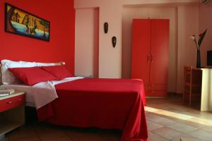 ein rotes Schlafzimmer mit einem Bett mit einer roten Wand in der Unterkunft Splashrooms in Spadafora