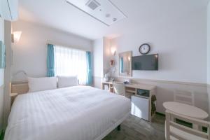 a bedroom with a bed and a desk and a clock at Toyoko Inn Daegu Dongseongro in Daegu