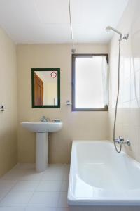 bagno con lavandino, vasca e lavandino di Hotel Costa Andaluza a Motril