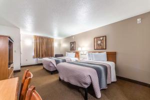 a hotel room with two beds and a table and chairs at Welcome Suites-O'Fallon in O'Fallon