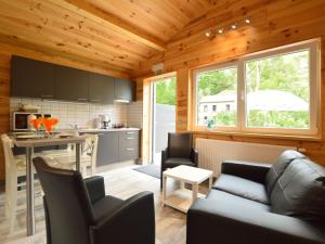 ein Wohnzimmer mit einem Sofa und einer Küche in der Unterkunft Chalet near Ourthe river and the city of Durbuy in Vieuxville
