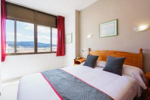 
a bedroom with a bed and a window at Hotel Costa Andaluza in Motril
