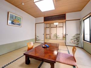 una sala da pranzo con tavolo e sedie in legno di Ryokan Niko a Koganei