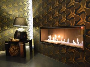 a living room with a fireplace and a lamp at Home in Welkenraedt with Jacuzzi Steam Shower in Welkenraedt