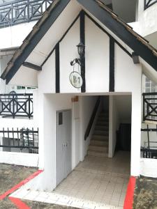 biały budynek z drzwiami i schodami w obiekcie The Haven Retreat B7-2-1 ( Silverpark) w mieście Bukit Fraser