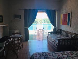 a bedroom with two beds and a view of a patio at Pousada Casa Atlântica in Angra dos Reis