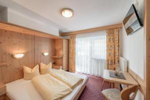 a hotel room with a bed and a desk at Ferienhaus Apart Sonnzeit in Sölden